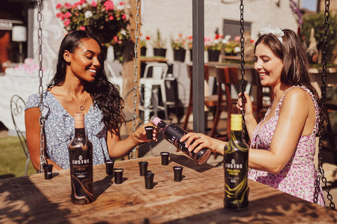 Two people sat sharing drinks of Lustre Vegan Cream Liqueurs.