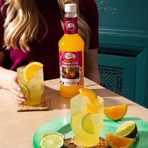 Someone with a drink that's been made using Master of Mixes passion fruit mix, a perfect bar ingredient for cocktails or mocktails. 