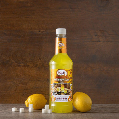 Bottle of Master of Mixes Whiskey Sour syrup with lemons on a wooden surface and background