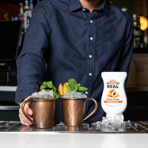 Someone making cocktails with Real peach puree syrup, Real syrups are perfect for cooking & baking, making cocktails or mocktails and dirty sodas. 