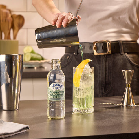 Someone making a cocktail using Franklin & Sons premium elderflower & cucumber tonic as a mixer. 