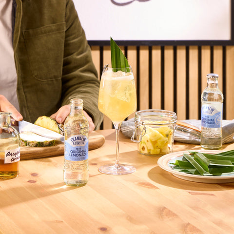 Someone making a cocktail using Franklin & Sons 1886 original lemonade, a premium soft drink. 