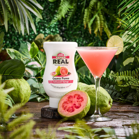 A guava cocktail made using Real guava syrup, with the syrup bottle next to the cocktail, Real syrups are gluten-free and vegan and are the perfect cocktail or mocktail ingredients. 
