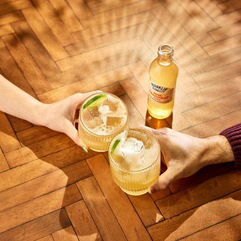A Franklin & Sons pink grapefruit soda, a premium soft drink and mixer, with people drinking the soda in two glasses. 