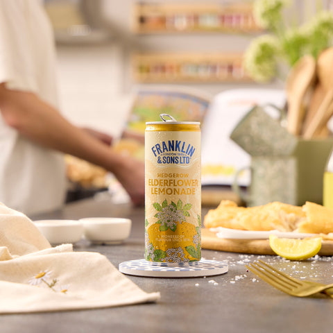 A can of Franklin & Sons hedgerow elderflower lemonade, a premium soft drink, next to fish and chips. 