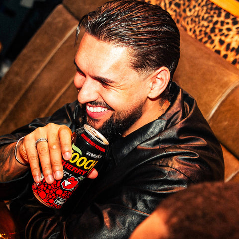 A man holding a can of Hooch Cherry, a premixed and ready to drink alcopop made with vodka and fruit juice. 