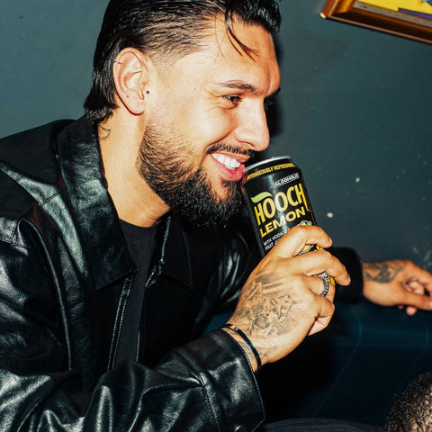 A man drinking a can of Lemon Hooch, a premixed, ready to drink alcopop. 