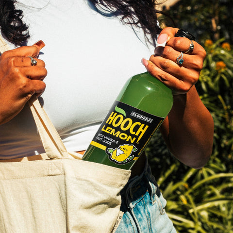 Someone grabbing a big bottle of Hooch Lemon out of their bag, Hooch is an alcoholic lemonade, premixed with vodka. 