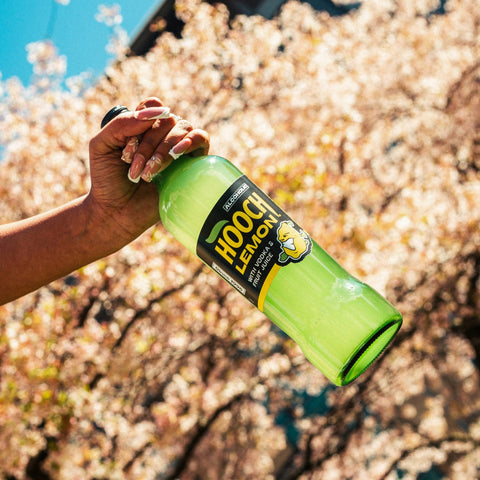 Someone holding a big bottle of Hooch Lemon, a premixed, ready to drink alcopop. 