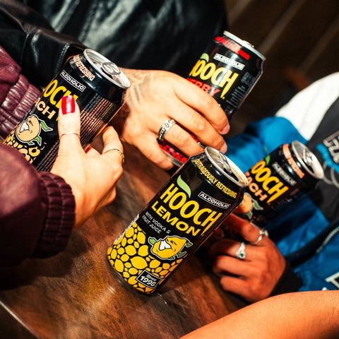 People drinking cans of Hooch in flavours, Cherry, Lemon and Peach, Hooch is a premixed alcopop made with vodka and fruit juices. 