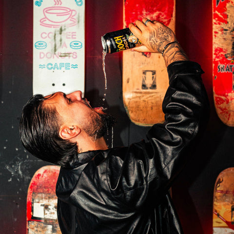 A person pouring a can of Hooch Peach into their mouth, Hooch is a premixed and ready to drink alcopop. 