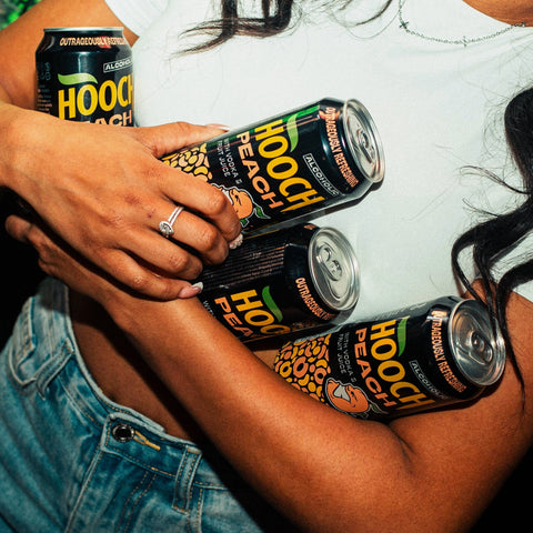 Someone carrying Hooch Peach cans, premixed and ready to drink alcopops. 