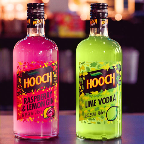 Four bottles of HOOCH spirits on a bar with a blurred bar background