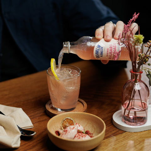 Someone pouring a bottle of Franklin & Sons spring rhubarb lemonade into a glass, Franklin & Sons offer premium soft drinks and mixers. 