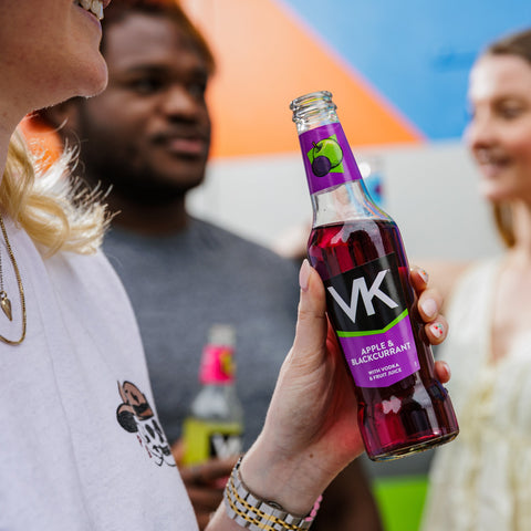 Someone drinking a bottle of VK apple and blackcurrant vodka mix, ready to drink alcopop.