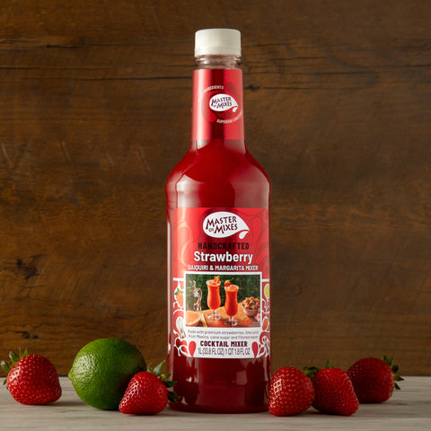 1L bottle of Master Of Mixes Handcrafted Strawberry Daiquiri & Margarita Cocktail Mixer in a lifestyle setting with a lime and strawberries.