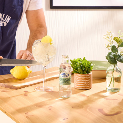 Someone making a gin and tonic using Franklin & Sons elderflower and cucumber tonic as a premium mixer. 