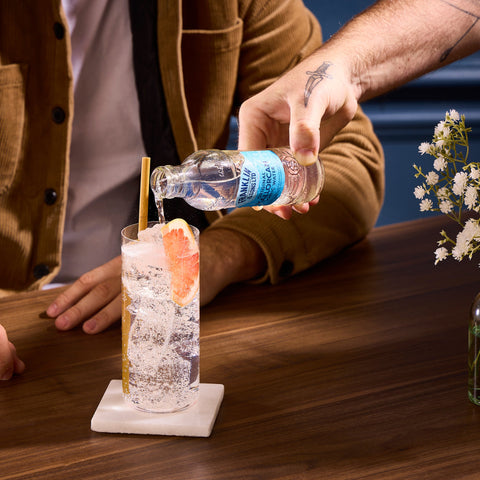 Someone pouring Franklin & Sons original Mallorcan tonic water into a drink to be used as a premium mixer. 