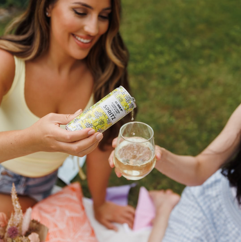 Someone pouring a can of All Shook Up Elderflower, Mint & Lime spritz into a glass, the spritz is a premixed, ready to drink canned cocktail.