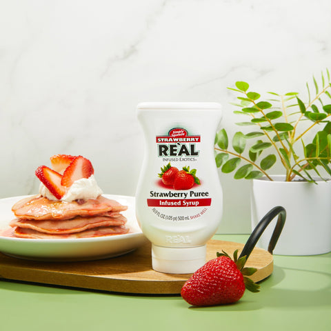 Strawberry Reàl Strawberry Puree bottle with pancakes and strawberries on a table