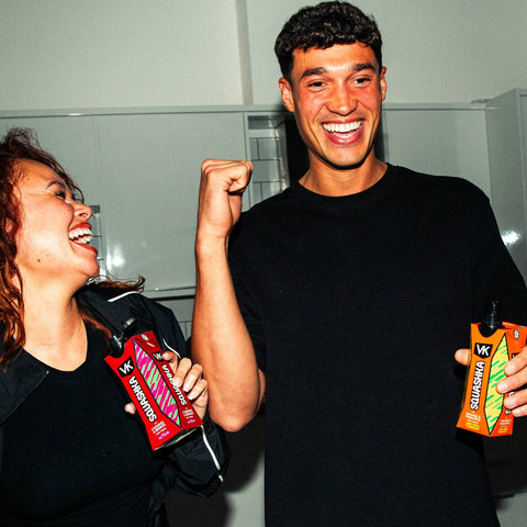 Two people holding VK Squashka drinks in a casual setting