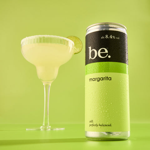 Luxury margarita cocktail next to a be. margarita canned cocktail