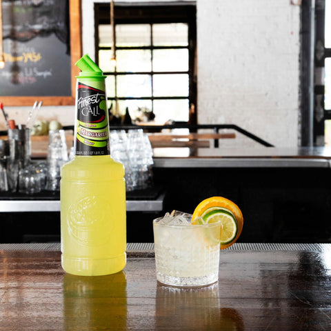 Finest Call Margarita Mixer with a margarita serve with fresh orange and lime