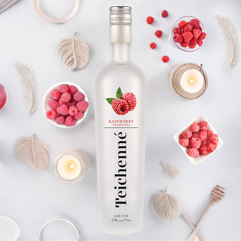 Teichenné raspberry liqueur bottle with raspberries and candles on a light background