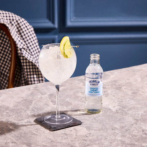 Franklin & Sons premium light tonic water being used as a premium mixer in the drink next to the bottle. 