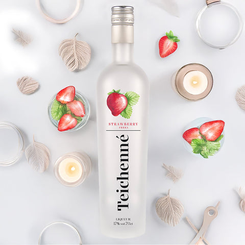 Teichenné strawberry liqueur bottle on a decorative background with strawberries and candles.