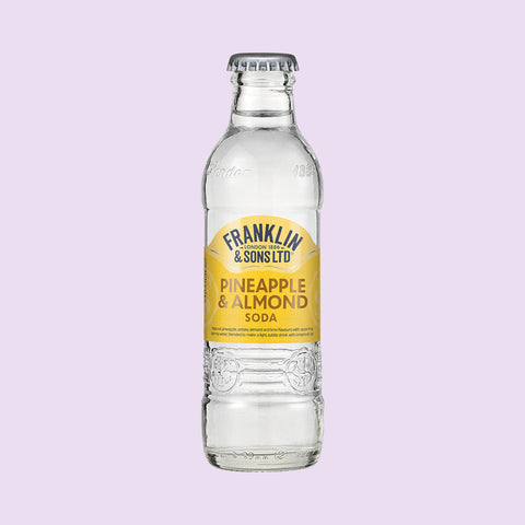 A glass bottle of Franklin & Sons Pineapple & Almond Soda, a premium soft drink.
