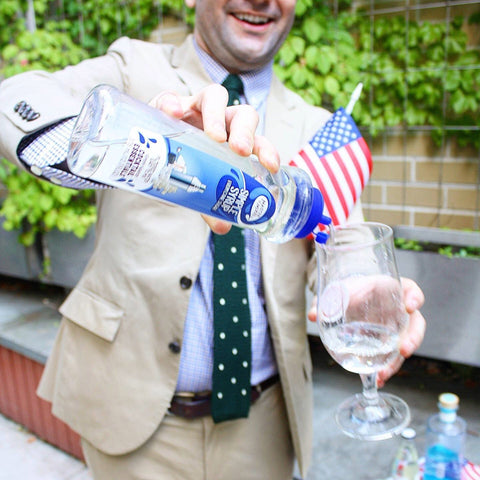 Someone pouring Master of Mixes Cocktail Essentials Simple Syrup into a cocktail. 
