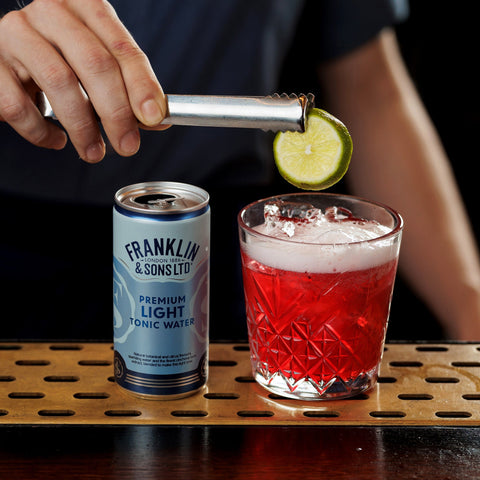 A bartender using Franklin & Sons premium light tonic water as a mixer in a drink. 