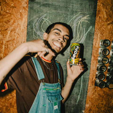 A person at a party drinking Soopa Hooch twisted tropical, ready to drink can.