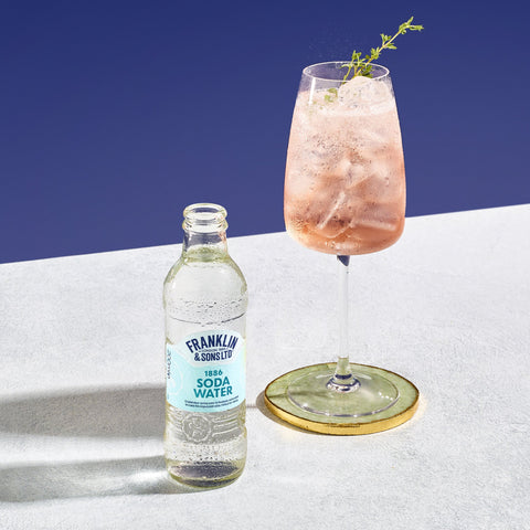 A cocktail of Franklin & Sons 1886 soda water with a bottle of the soda water next to it. 