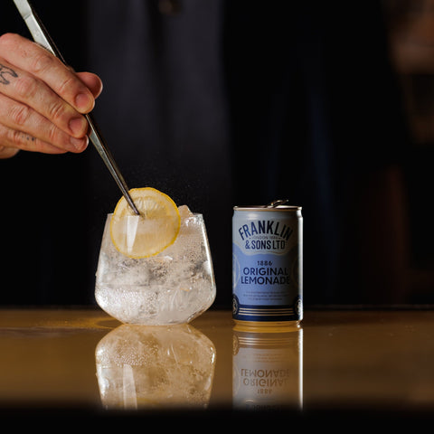 Franklin & Sons 1886 original lemonade, a premium soft drink and mixer, next to a glass of Franklin & Sons 1886 original lemonade. 