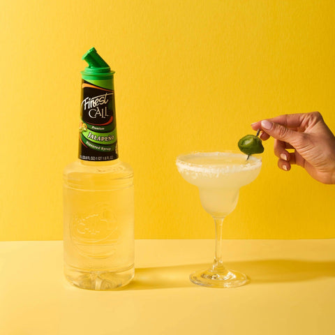 A spicy margarita made with Finest Call Premium Jalapeno flavoured syrup, with the Finest Call bottle placed next to the cocktail. 