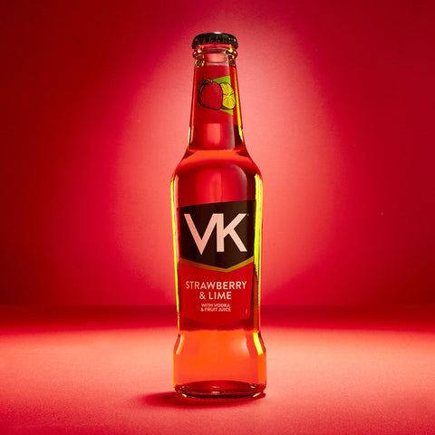 A bottle of VK strawberry and lime, a vodka and fruit juice alcopop on a red background. 