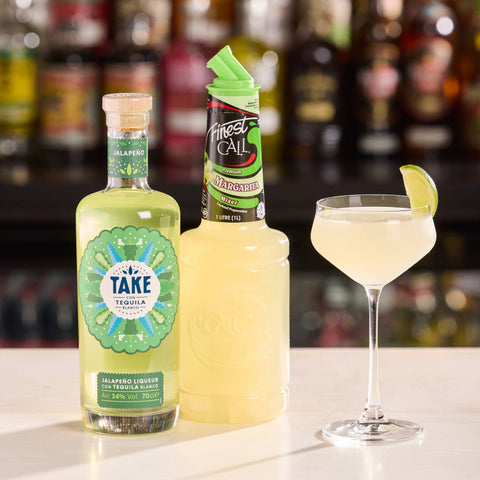 Bottles of Take Tequila Jalapeno and Finest Call Margarita mixer with a cocktail in a glass.