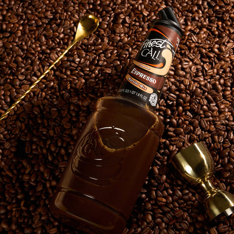 Finest Call Espresso Martini Mix on coffee beans with a spoon and measurer