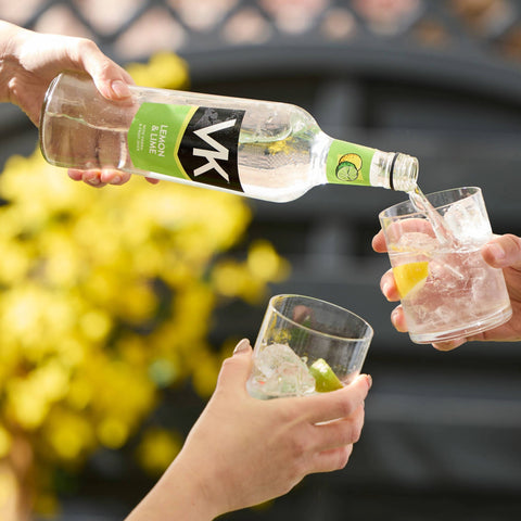 Someone pouring Lemon & Lime VK into glass