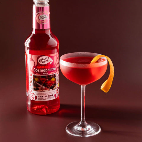 A bottle of Master of Mixes Cosmopolitan cocktail mixer, with a Cosmopolitan cocktail next to the bottle.