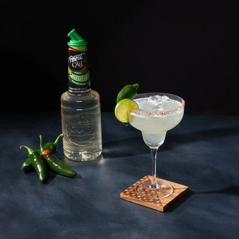 A spicy margarita made with Finest Call Premium Jalapeno flavoured syrup, with the Finest Call bottle placed next to the cocktail. 