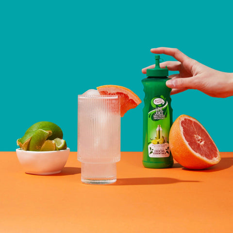 A cocktail that's made with Master of Mixes Cocktail Essentials Single Pressed Lime Juice, not from concentrate. The Lime Juice bottle is placed behind the cocktail. 