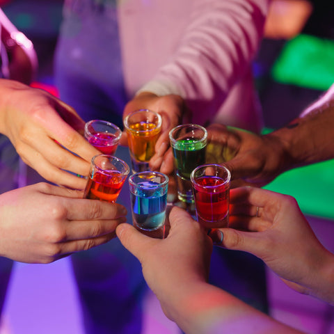 People toasting multi-coloured shots of Corky's. 