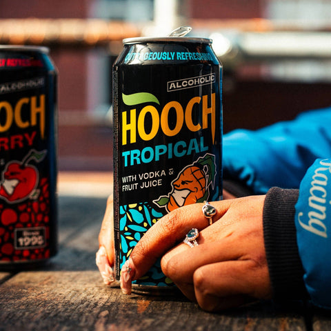 Someone holding a Hooch tropical can, a ready to drink alcopop.