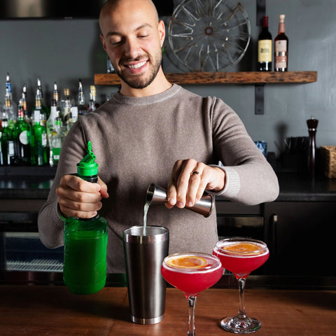 Finest Call Single Pressed Lime Juice at a bar being poured into a cocktail shaker