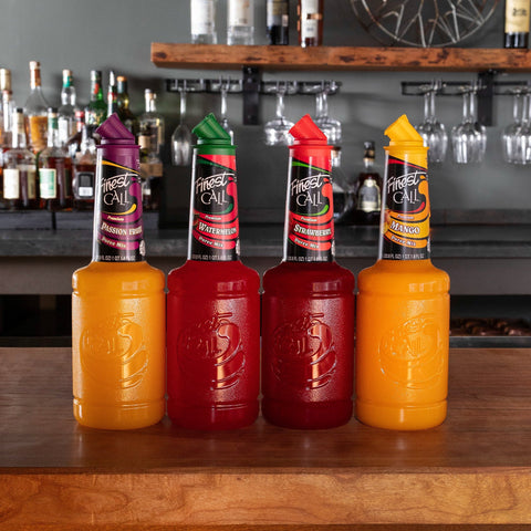 Three bottles of Finest Call Purees on a bar counter with a bar setting in the background.