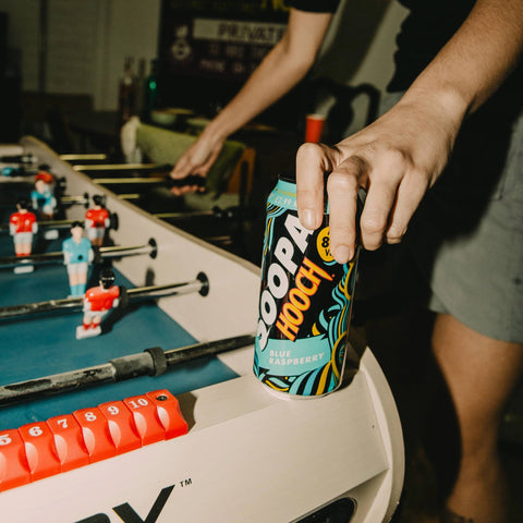 Soopa Hooch Blue Raspberry on top of a retro 90s foosball table