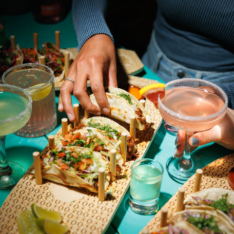 People eating tacos and drinking margaritas and having shots made with Take Tequila.